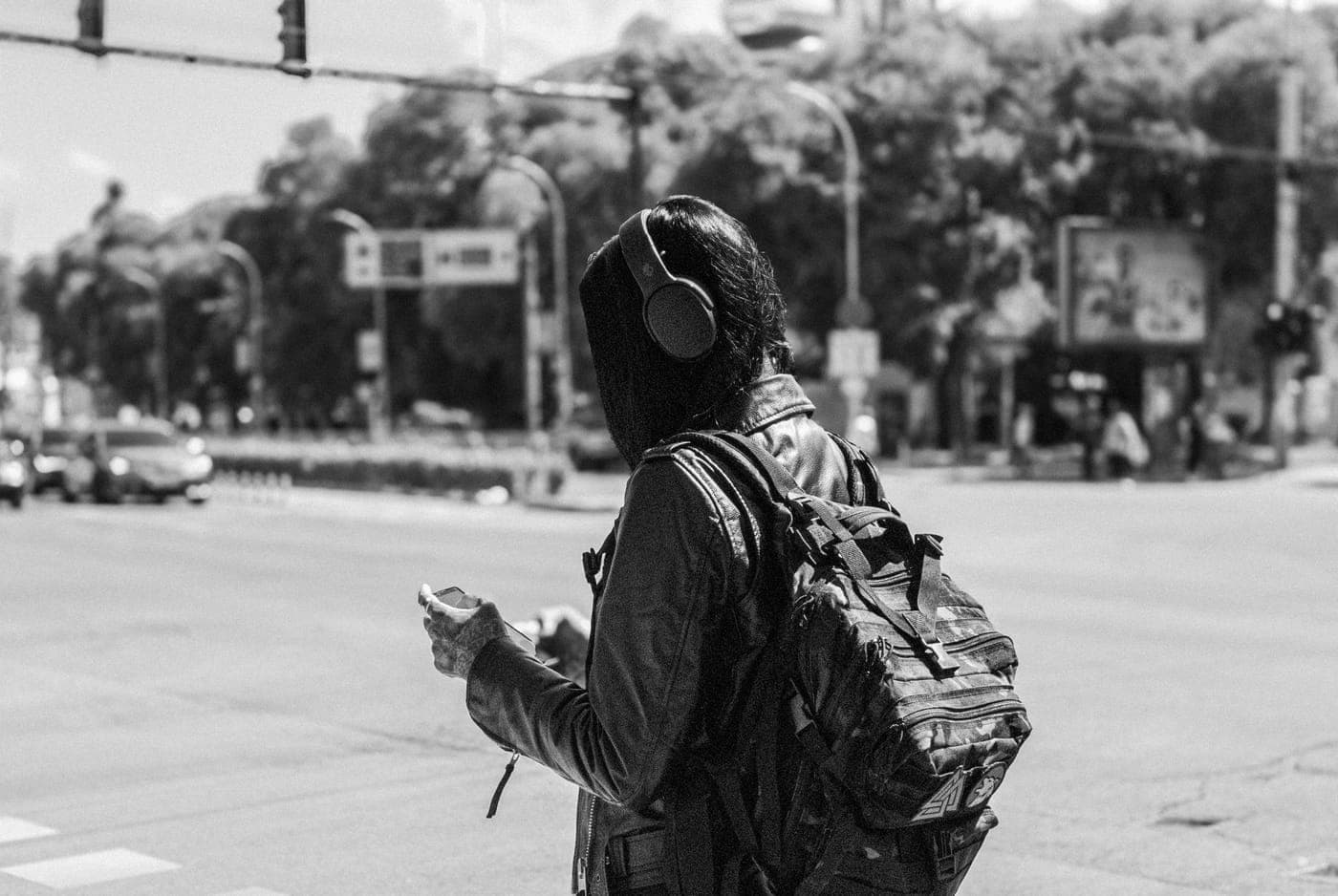 A person walking with headphones on a city street
